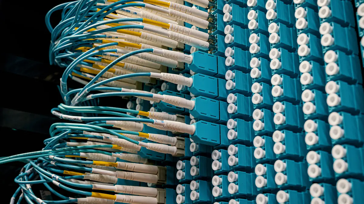 Fiber optic patch cables connected to a blue patch panel